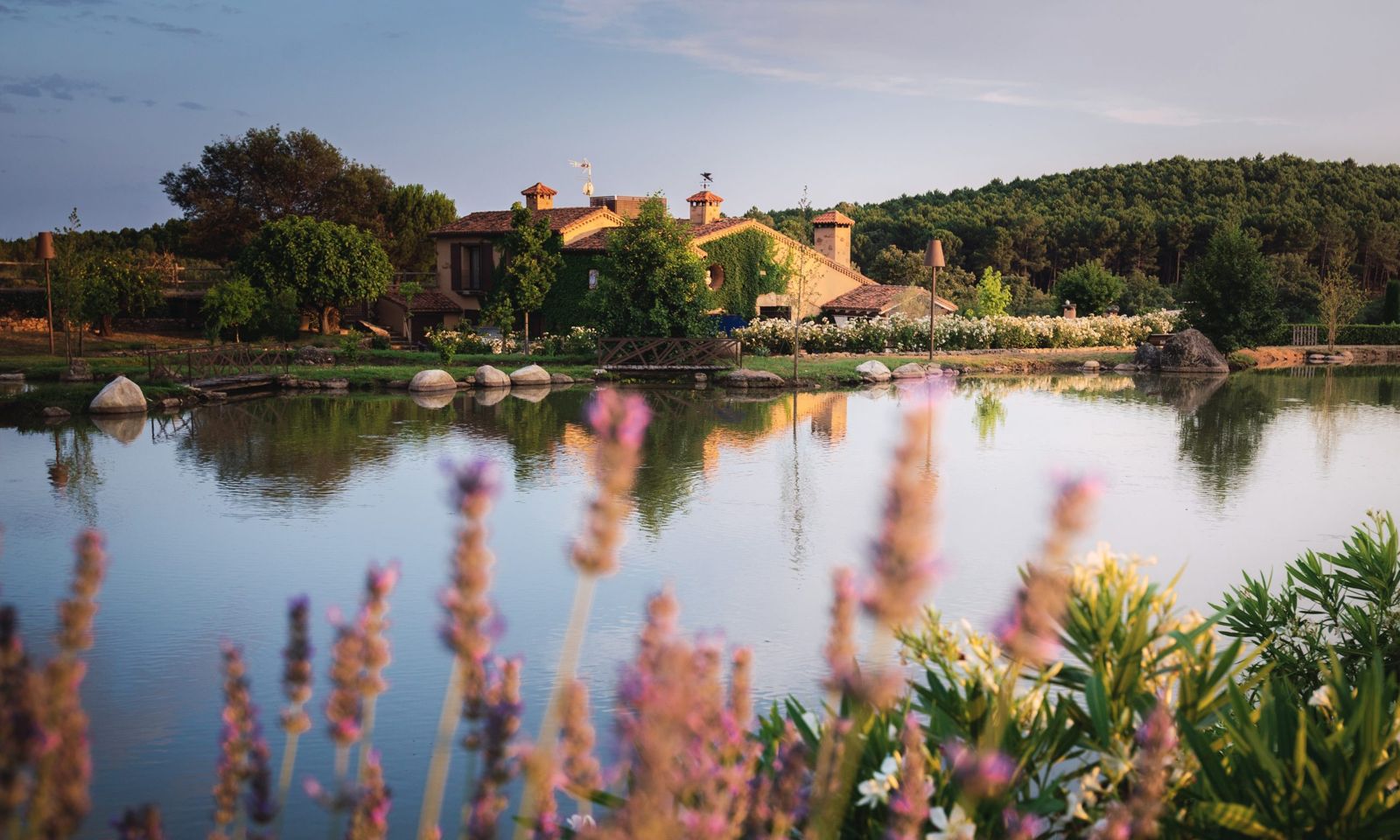 La casa de la Quinta de la Cerca reflejada en el lago, con lavanda en primer plano