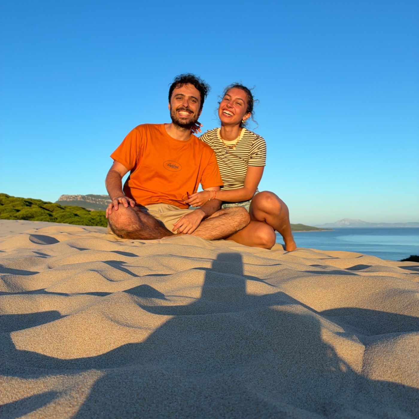 Jorge y Ángela sentados juntos en la playa